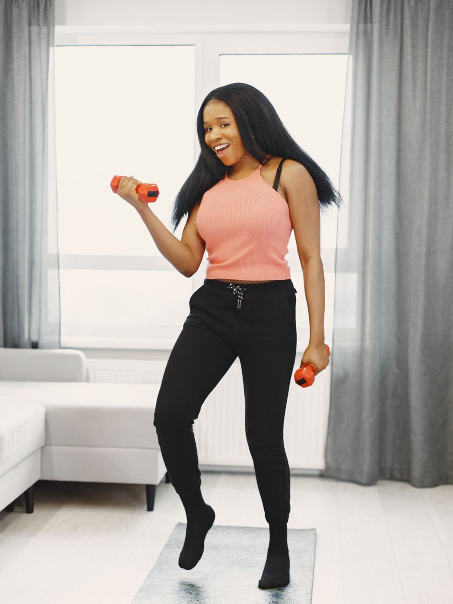 Woman exercising with dumbbells at home